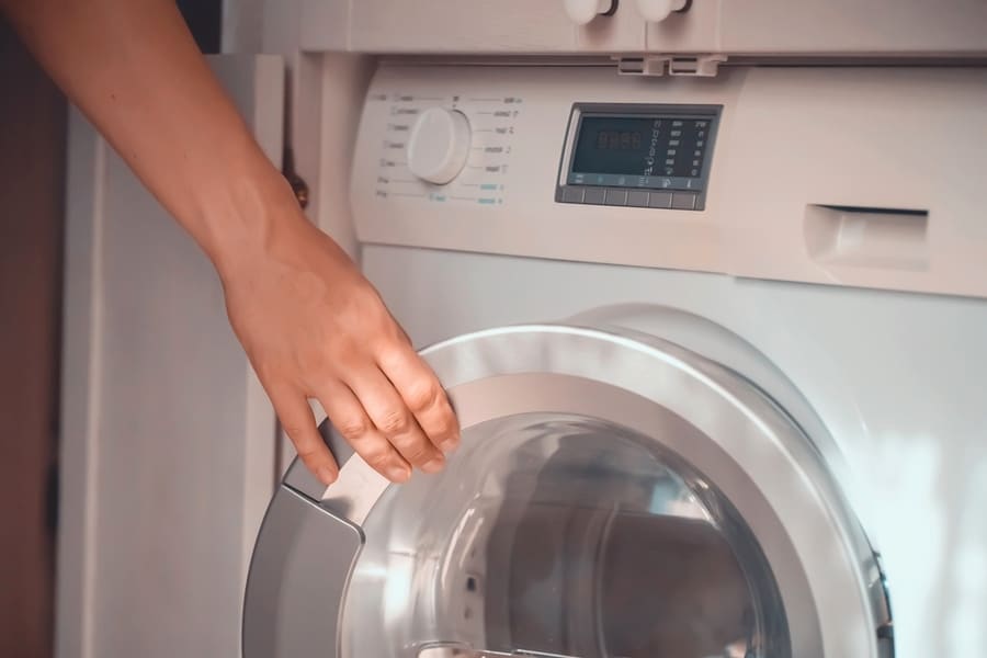 A Male Hand Opens The Door Of A New Washing Machine In His Modern