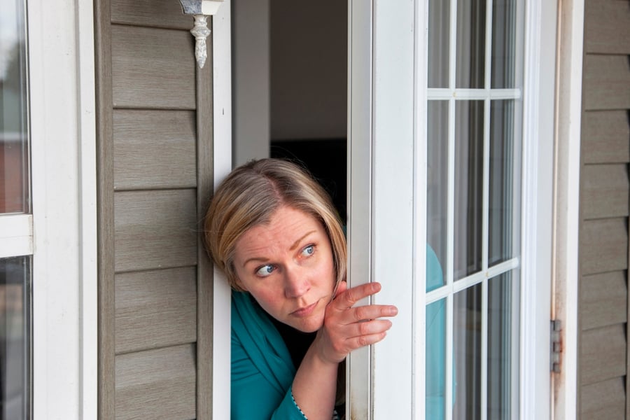 A Woman Peeks Out Her Front Door