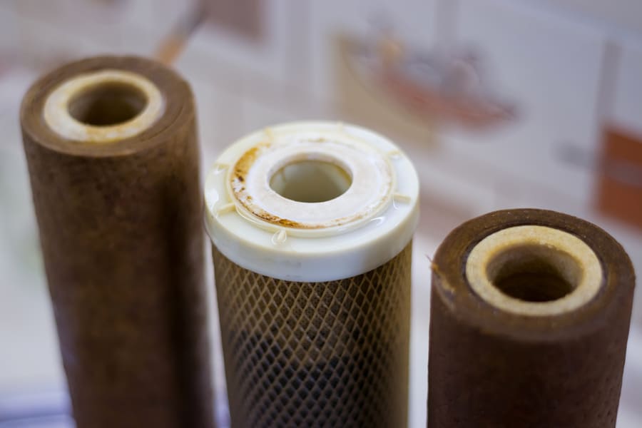 Dirty Used Reverse Osmosis System Cartridges On A Kitchen Background