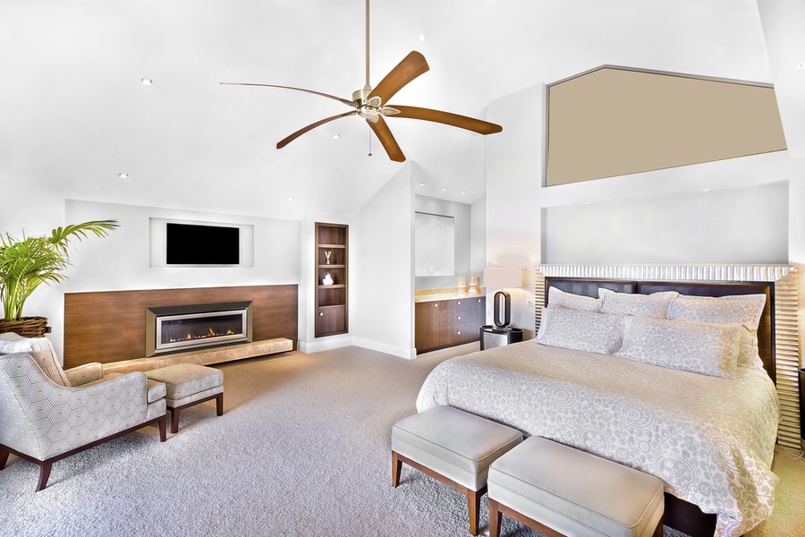 Modern Bed Area Including Furniture, Television Is Attached To Wall, One Chair Close To Flower Pot And Fan On Ceiling