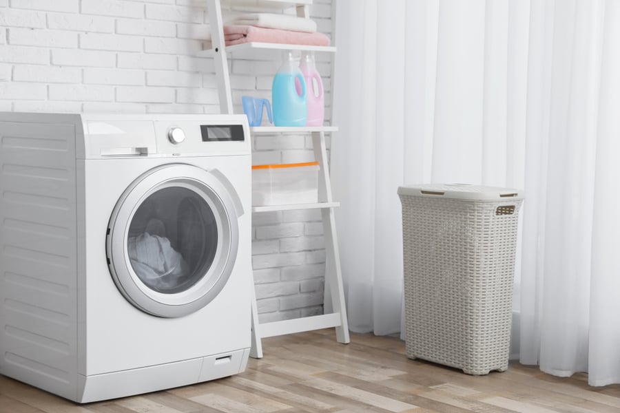 Modern Washing Machine Near Brick Wall In Laundry Room Interior