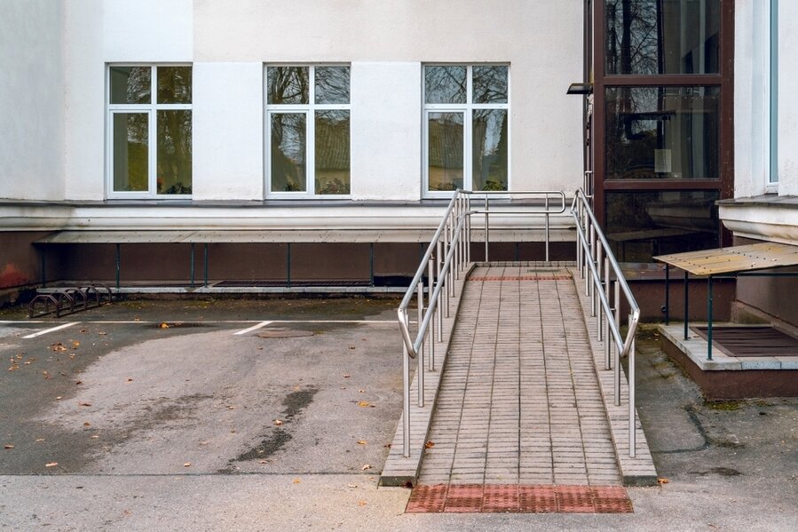 Ramp For Wheelchairs And Glass Elevator On A Multistory House Facade