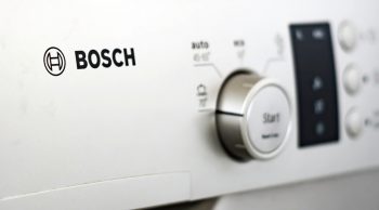 The Bosch Logo Printed On The Front Panel Of A Gray Dishwasher