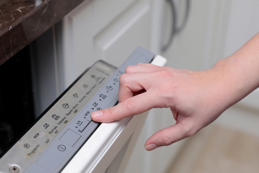 The Hand Of A Woman Who Opens The Dishwasher