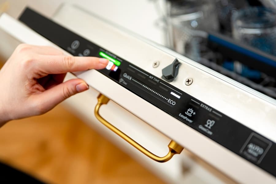 Woman Choosing Eco Mode Program On The Digital Control Panel Of The Dishwasher