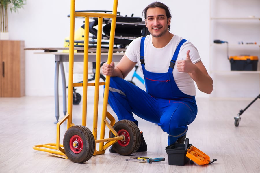 Young Male Repairman Repairing Trolley Indoors