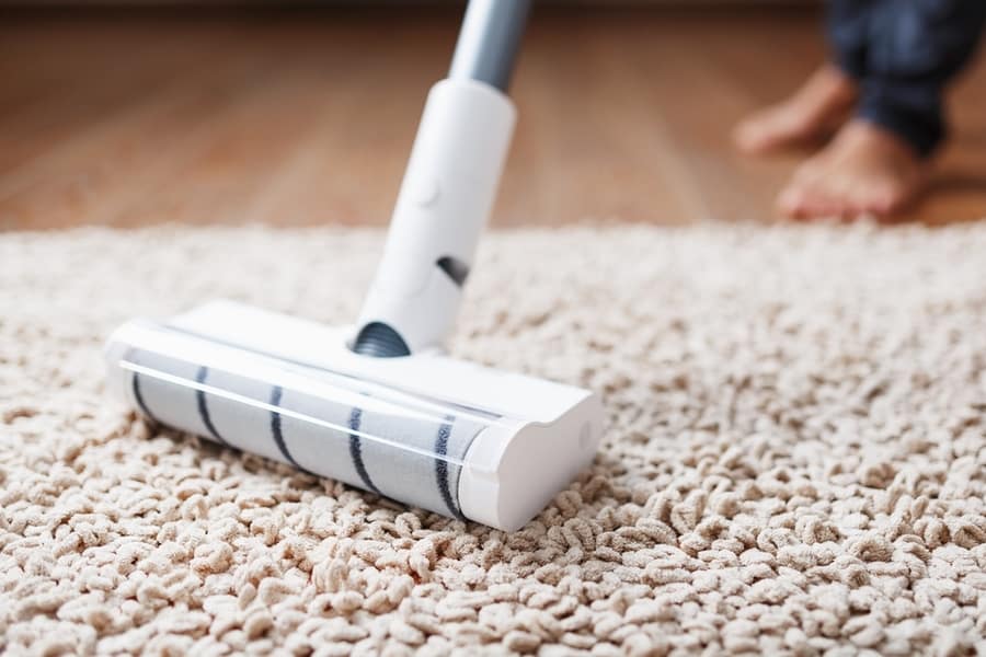 A Cordless Vacuum Cleaner Cleans The Carpet In The Living Room With The Bottom Of The Legs. Modern Technologies For Cleaning The House. Turbo Brush.