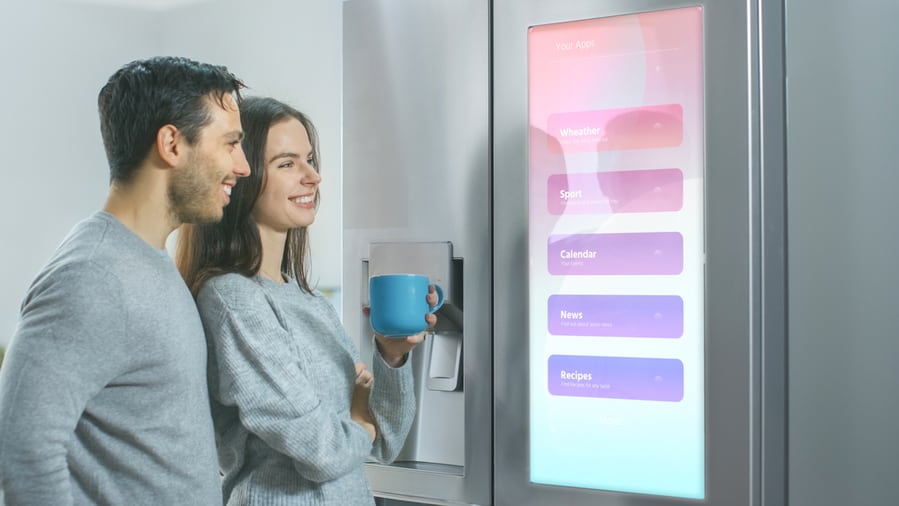 A Couple Looking At The Smart Fridge