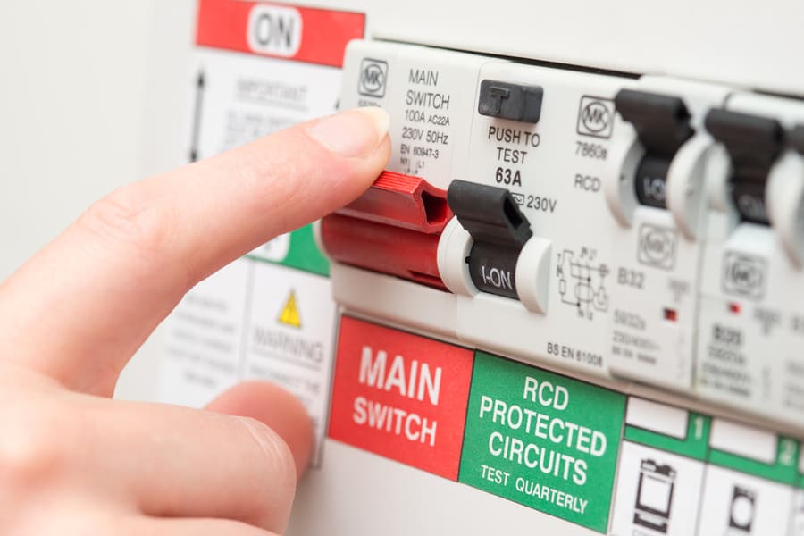 A Finger Is About To Switch Off A Large Red Mains Switch On An Rcd Circuit Breaker Board