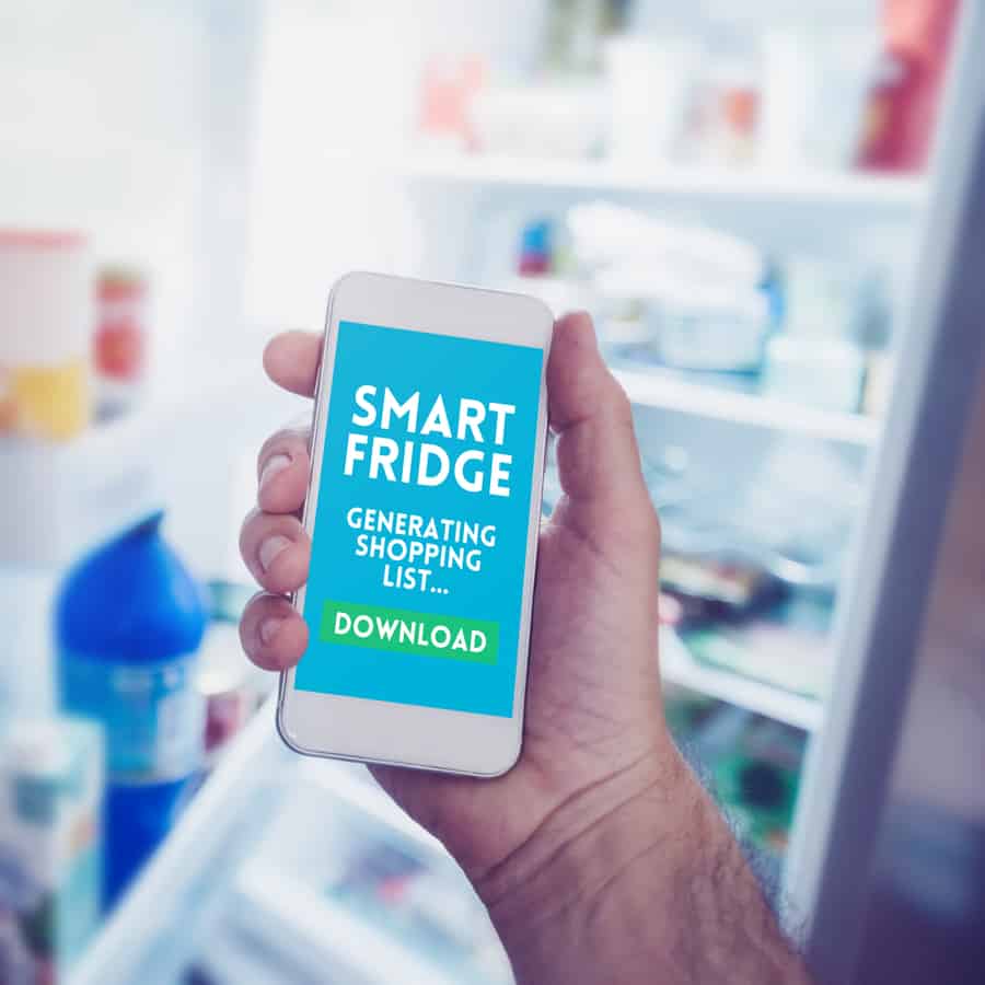A Man Generating A Shopping List Through A Phone App Connected To The Smart Fridge