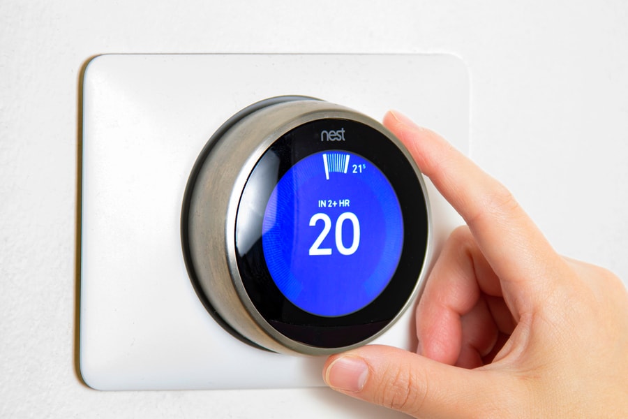 A Person Cooling Down Home Air Conditioning, And The Temperature Is On Centigrade Celsius Metrics Using A Nest Smart Thermostat On A White Wall