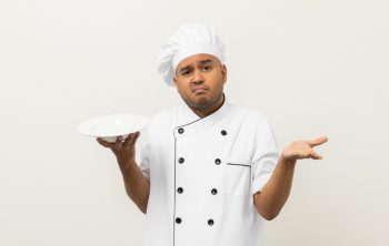 Bad Smell And Not Tasty Food. Young Asian Master Chef Holding Dish Has Rotten Food Dishes Smelly And Disgusting. Dirty Food With Chef On Isolated Background.