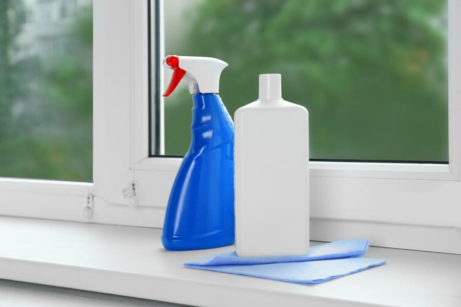 Bottles Of Cleaning Products And Dustrag On Windowsill