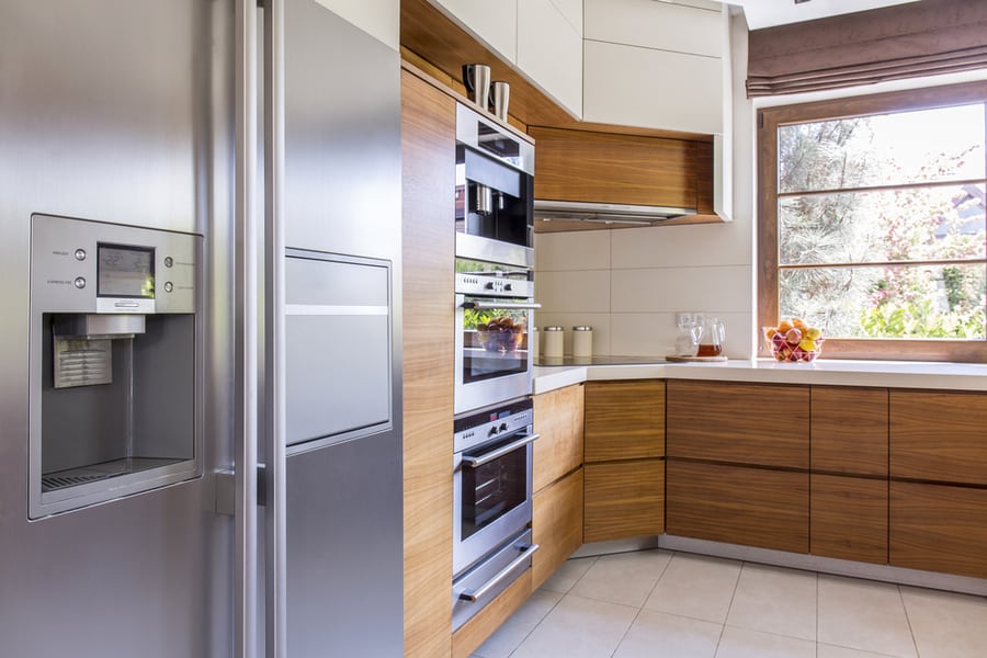 Corner Of A Freshly-Renovated Kitchen With Wooden Cabinet Fronts And A Side By Side Refrigerator