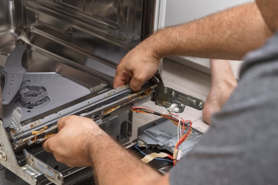 Echnician Or Plumber Repairing The Dishwasher In A Household. The Rubber Seal Is Damaged