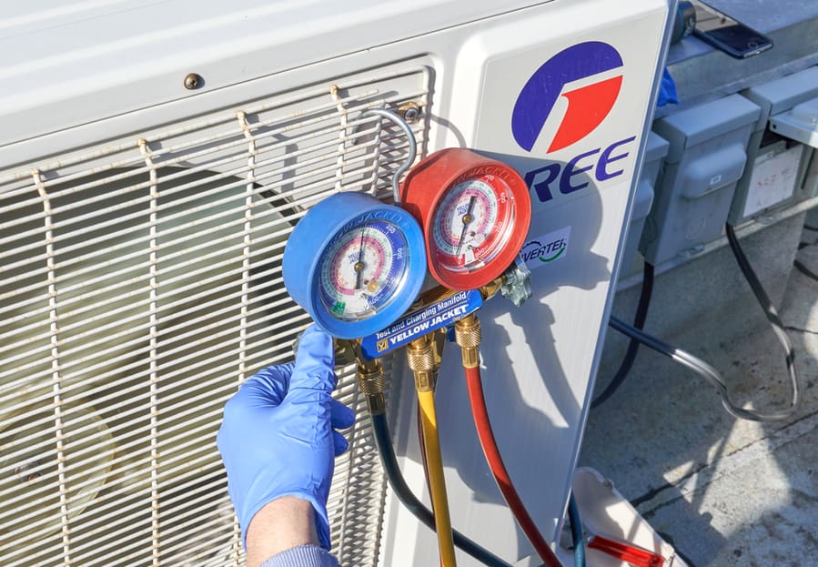 Engineer Checking Ac Refrigerant Level And Refilling Freon. Gree Electric Is A Partially State-Owned Chinese Appliance Manufacturer.