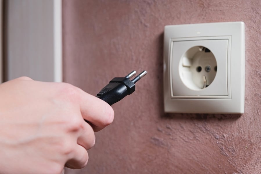 Euro Socket Woman's Hand Inserts An Electric Plug Into A Socket