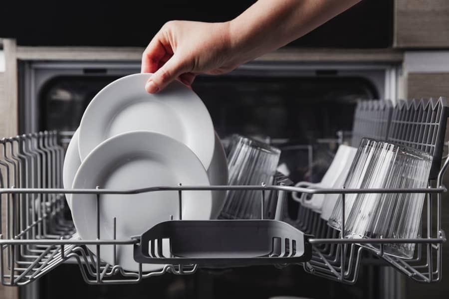 Female Hand Loading Dished, Empty Out Or Unloading Dishwasher With Utensils.
