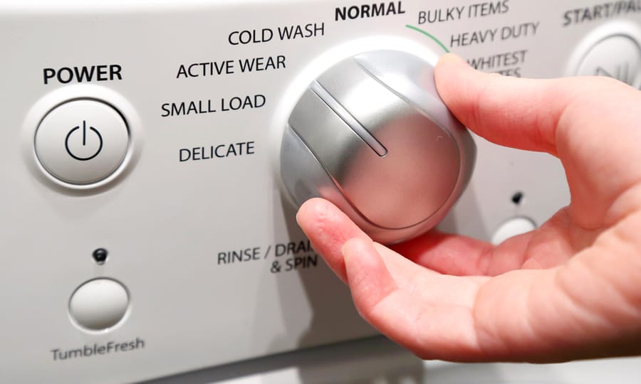 Girl's Hand Adjusting Washing Machine