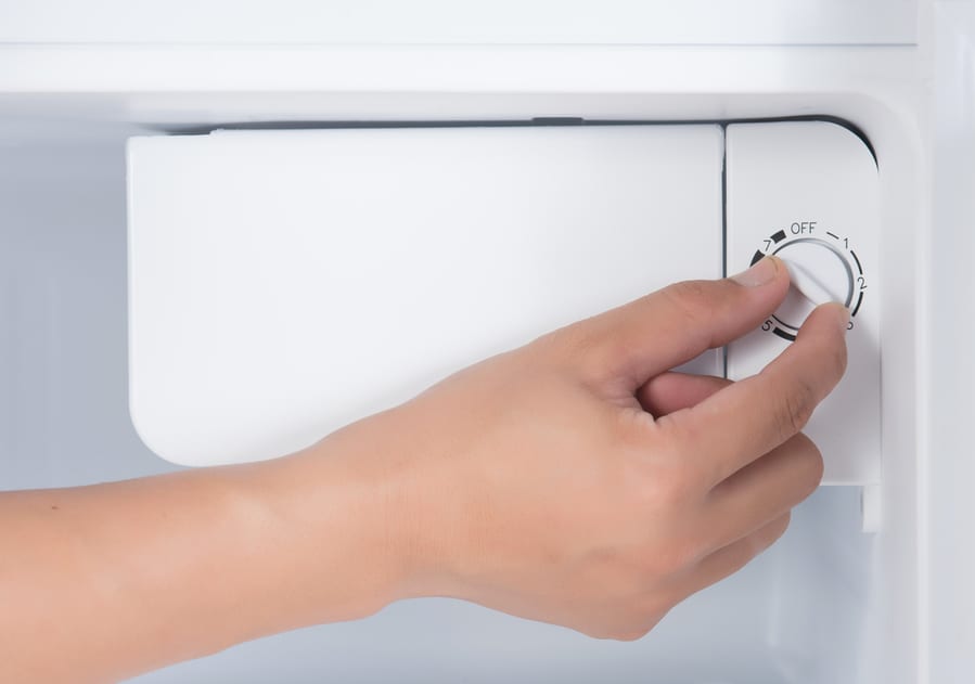 Hand Rotating The Temperature Adjuster Of Refrigerator To Turn It Off