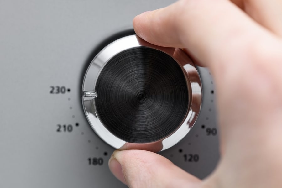 Hand Twists Round Temperature Adjustment Button In The Microwave Oven