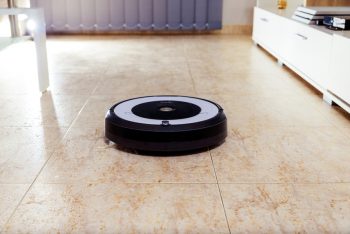 Irobot Roomba Cleaning The Floor Of The Room. Vacuum Cleaner Robot. Household Cleaning Concept. New Technologies.