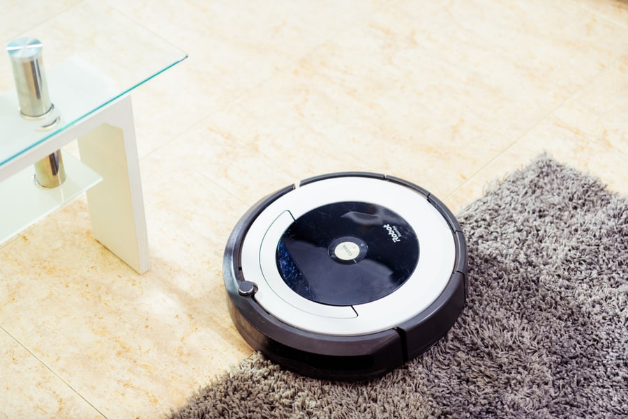Irobot Vacuum Cleaner Roomba Cleaning A Gray Carpet. Home Cleaning Concept.
