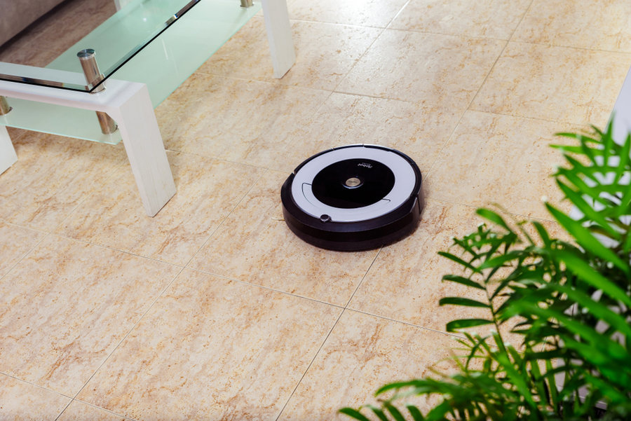 Irobot Vacuum Cleaner Roomba Cleaning Under A Bed.irobot Roomba Cleaning The Floor Of The Room. Vacuum Cleaner Robot. Household Cleaning Concept. New Technologies.