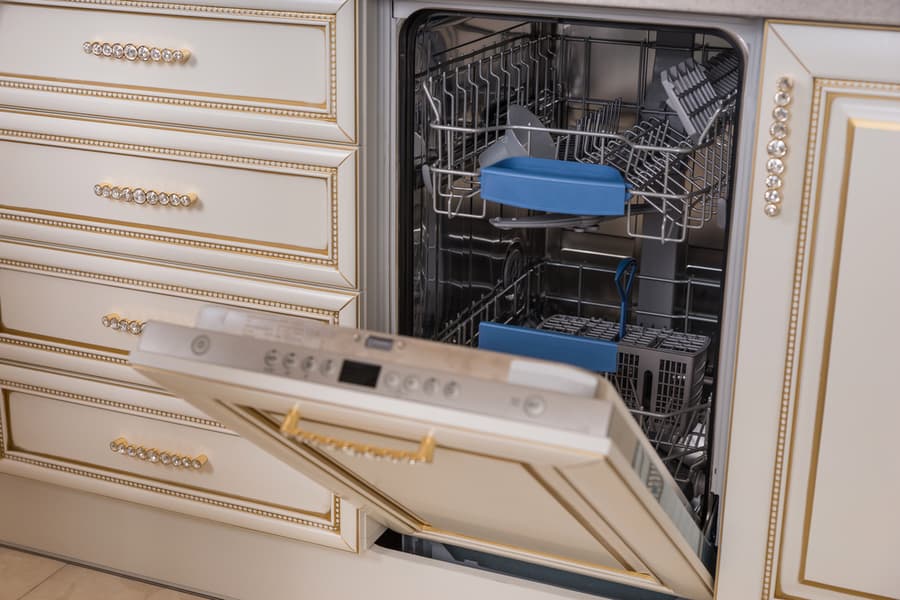 Kitchen Detail Of Dish Washer Appliance With Open Door To Reveal Racks And A Few Dishes