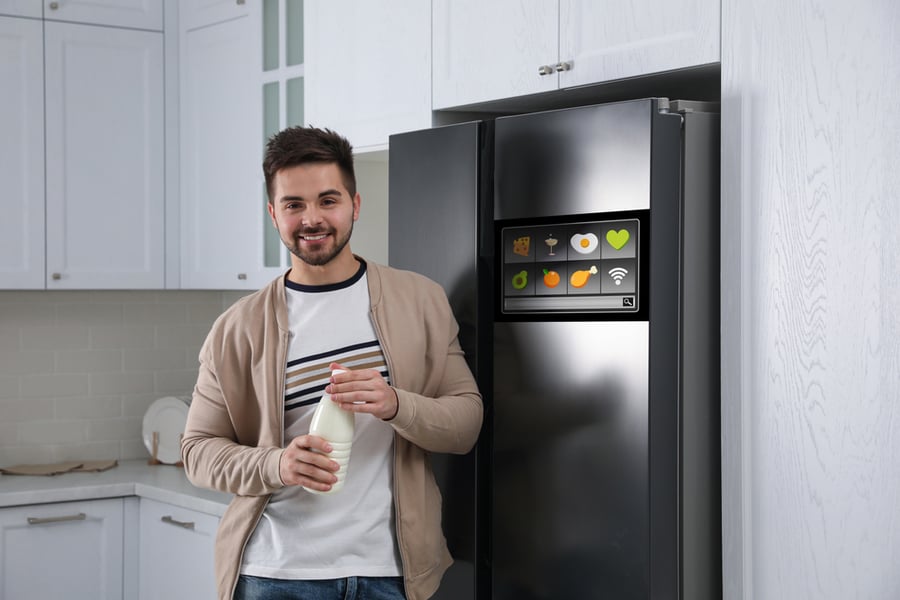 Man Near The Display Panel Of The Smart Fridge