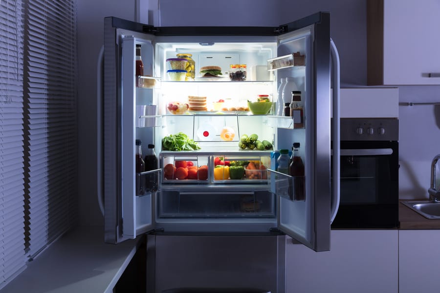 Open Refrigerator Full Of Juice And Fresh Vegetables In Kitchen