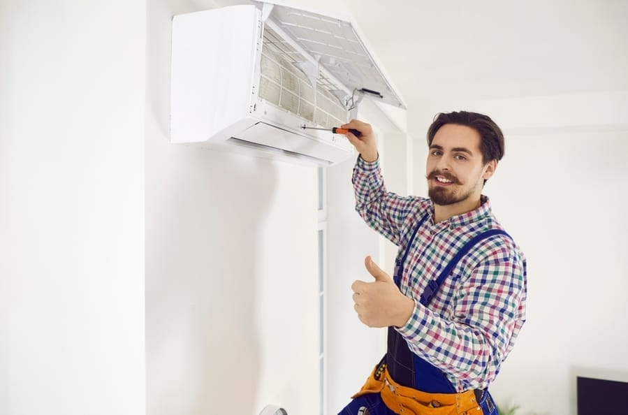 Portrait Of Happy Handsome Moustached Ac Maintenance Service Worker Holding Screwdriver, Looking At Camera, Smiling And Showing Thumbs Up After Repairing Wall Air Conditioner Unit At Home