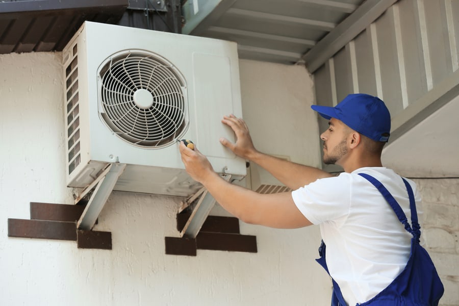 Professional Technician Maintaining Modern Air Conditioner