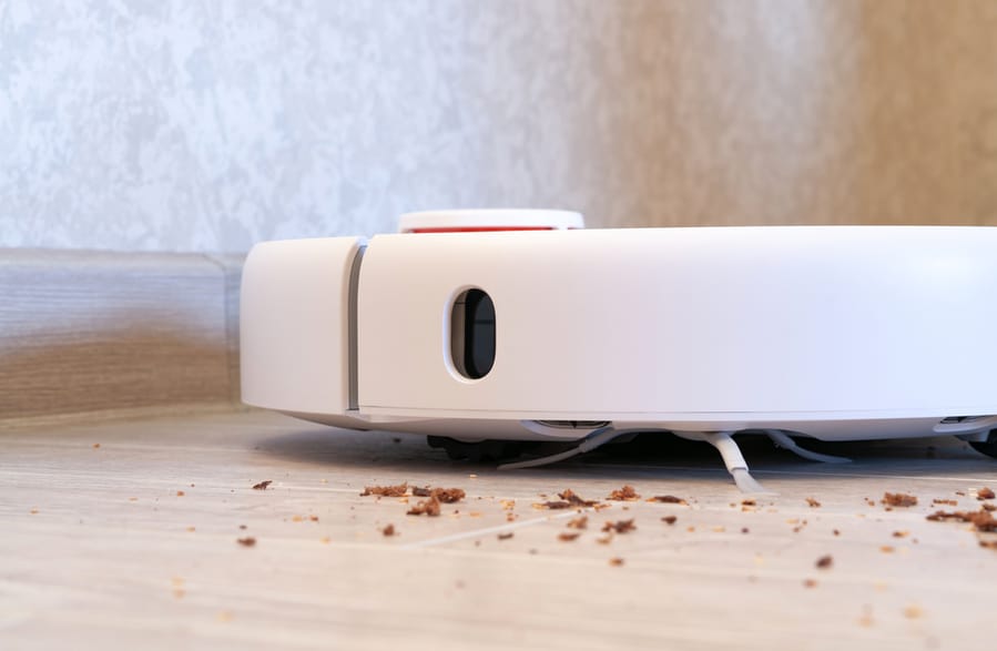 Robotic Vacuum Cleaner Removes Breadcrumbs From The Laminate Wood Floor