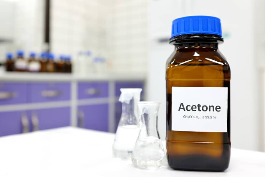 Selective Focus Of Pure Acetone Solution In Brown Glass Amber Bottle Inside A Chemistry Laboratory. White Background With Copy Space.