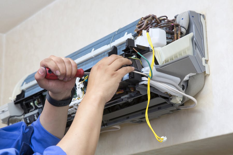 Technician Repairing Air Conditioner On The Wall