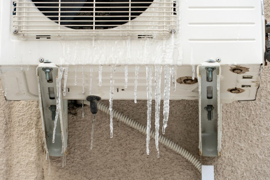 The Outdoor Unit Of The Air Conditioner Is Covered With Ice And Icicles