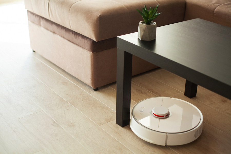 Vacuum Cleaner Robot Runs On Wood Floor In A Living Room