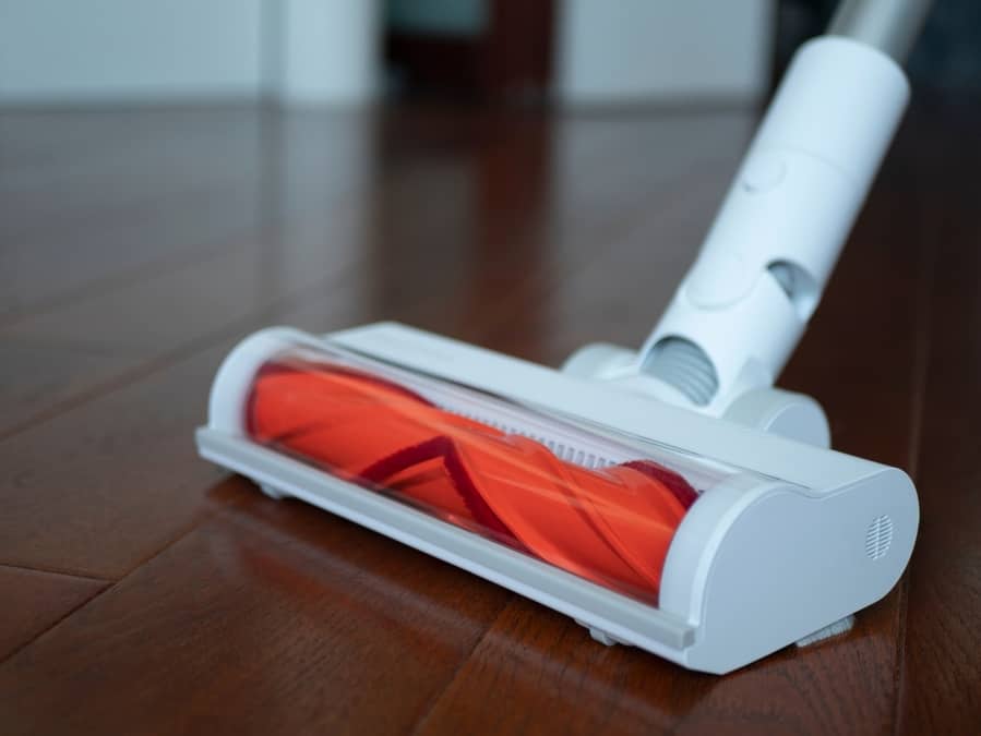 White Vacuum Cleaner With V-Shaped Rotating Roller Head, Selective Focus. Concept Of Dry Cleaning, Vacuuming The Room