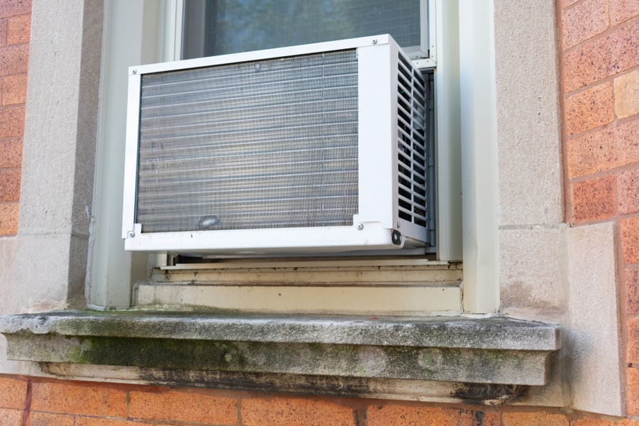 Window Air Conditioning Unit Seen From Outside On A Brick Urban Building
