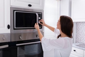 Woman Using Microwave Oven