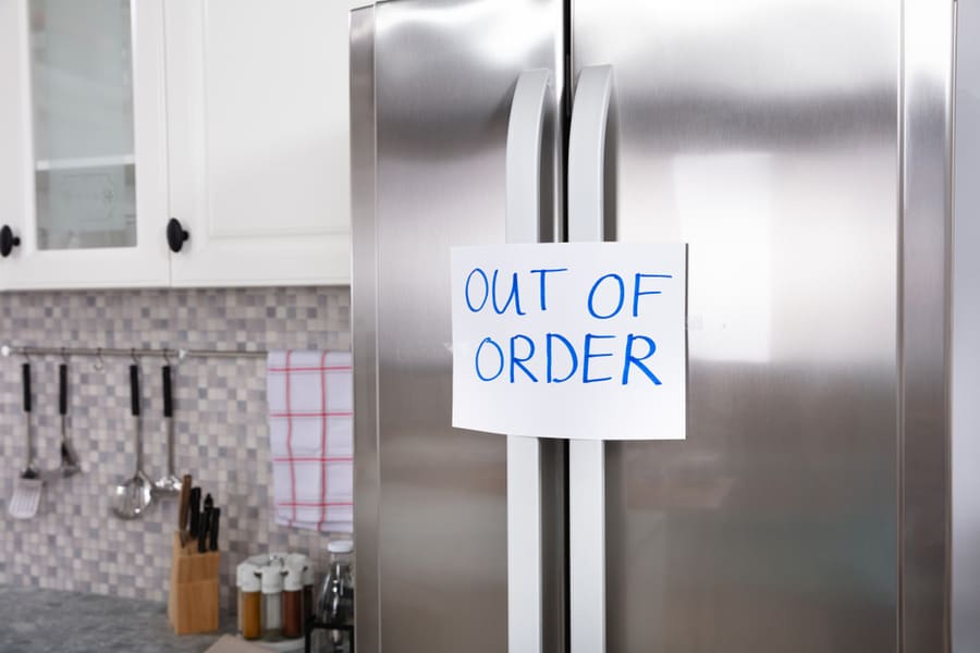 Written Text Out Of Order Message On Paper Over The Closed Refrigerator In Kitchen