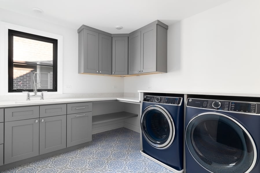 A Beautiful Laundry Room With Blue Washer And Dryer Appliances