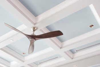 A Large Interior Fan On A Blue Coffered Ceiling