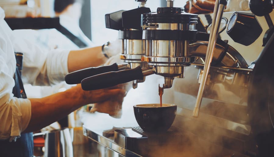 Barista Make Coffee Latte Art With Espresso Machine In Cafe Vintage Color Tone