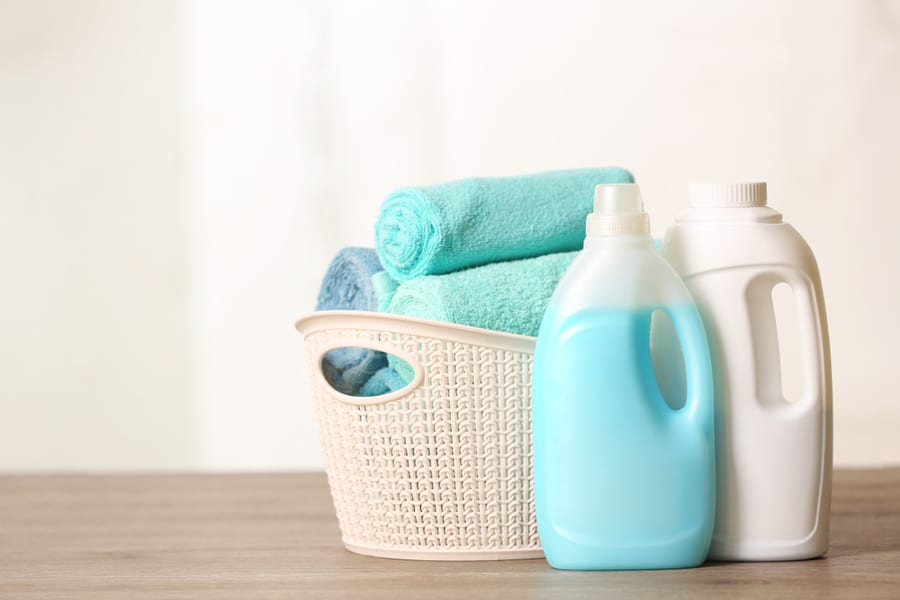 Basket With Clean Towels And Detergents On Table. Space For Text.