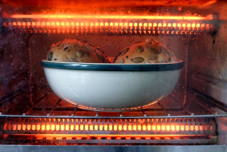 Bread Bun Seen Through A Glass Cover Being Heated Up By The Glowing Internal Heating Rods