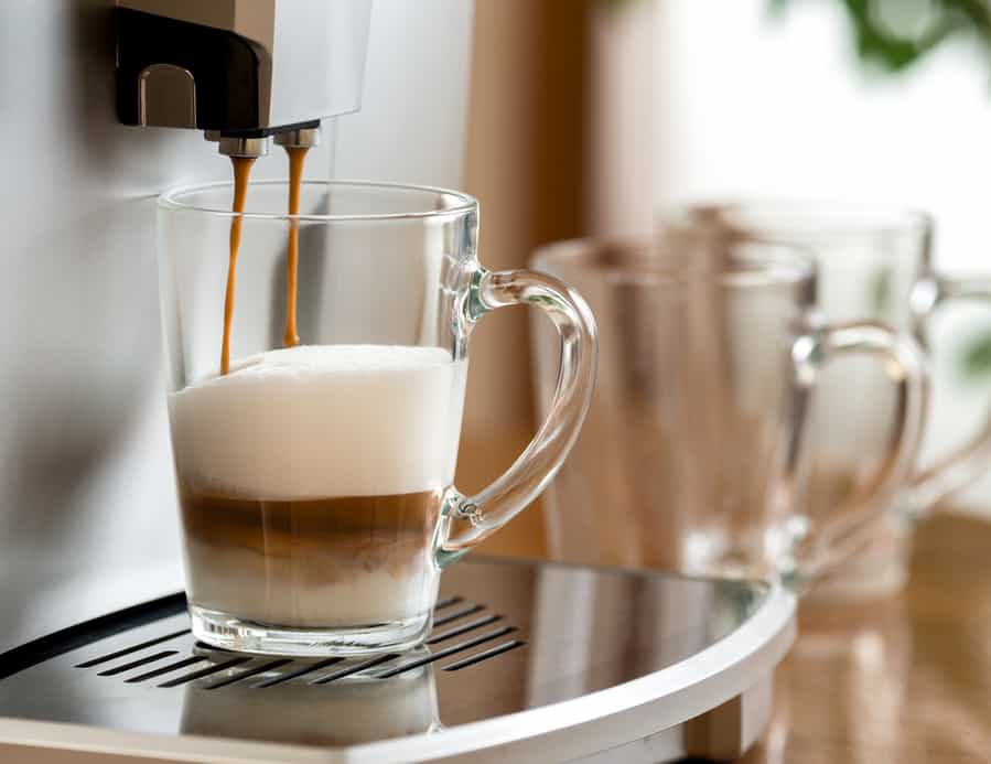 Cappuccino Coffee Prepared In A Glass Cup With Help Of Machine