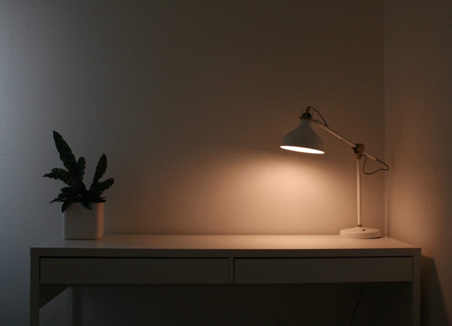 Clean White Desk With A Plant And Lamp During Evening Home Office