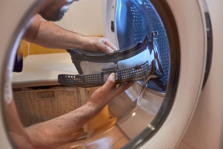 Craftsman Cleans The Lint Filter From The Tumble Dryer In The Bathroom Or Laundry Room